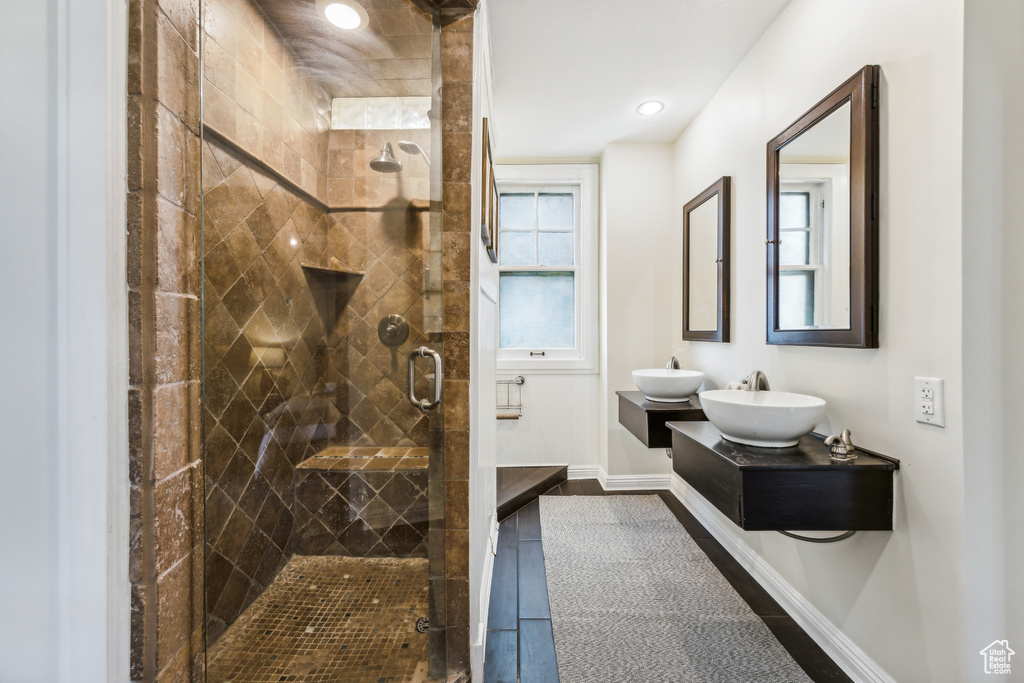 Bathroom featuring vanity, tile patterned flooring, and a shower with door