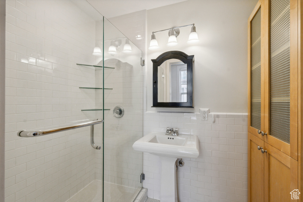 Bathroom with a shower with door and tile walls