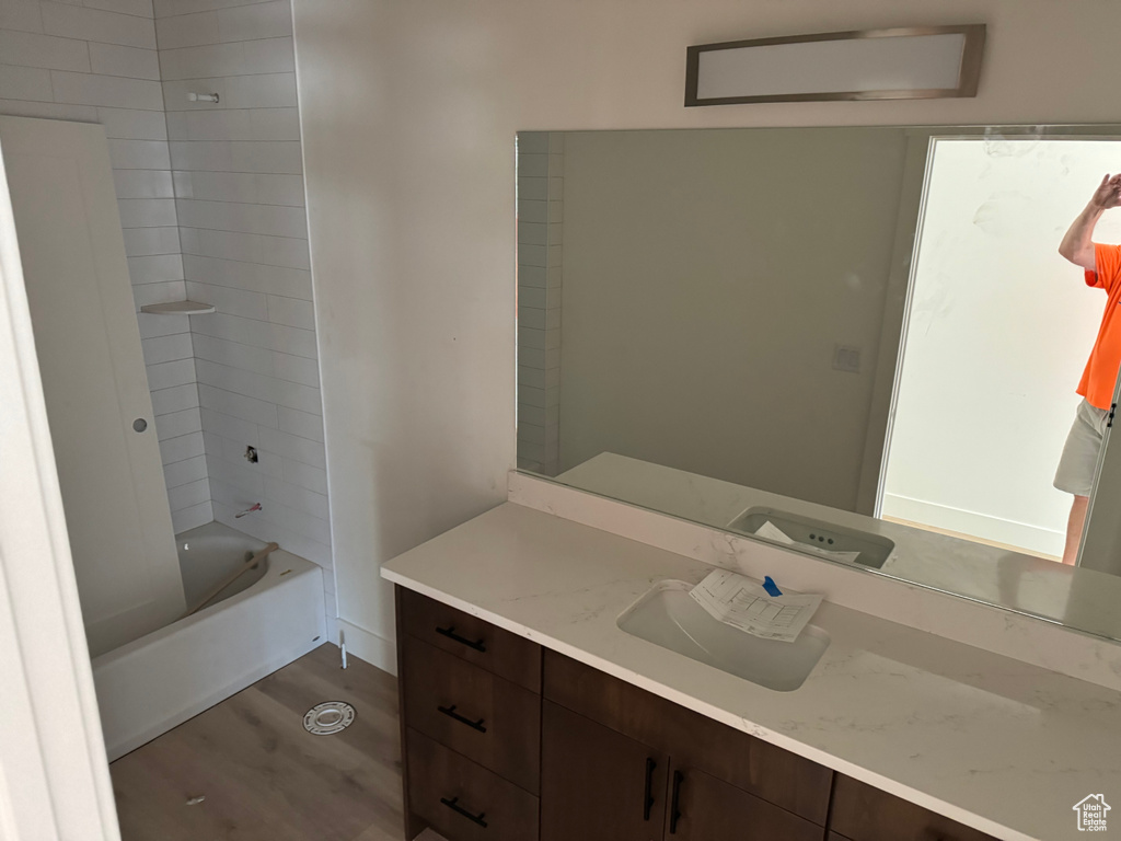 Bathroom featuring vanity, hardwood / wood-style floors, and tiled shower / bath combo