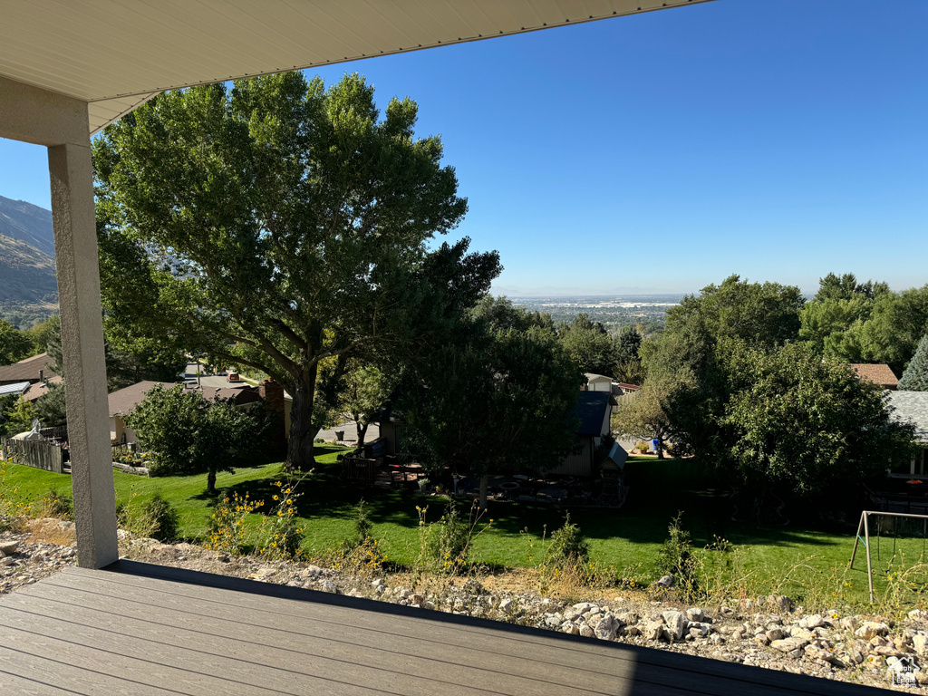 Deck with a yard and a mountain view