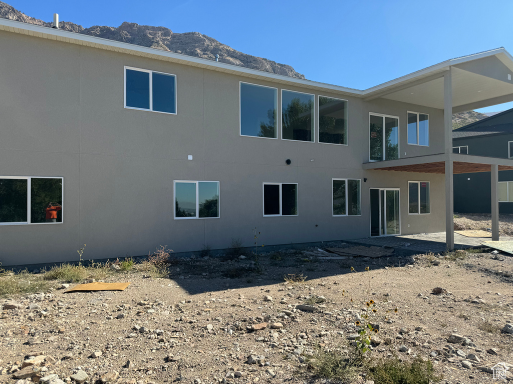 Back of house featuring a mountain view and a patio area