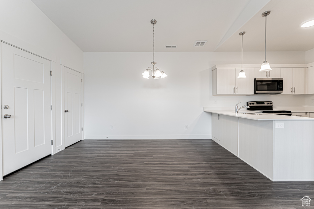 Kitchen with a chandelier, visible vents, appliances with stainless steel finishes, and light countertops