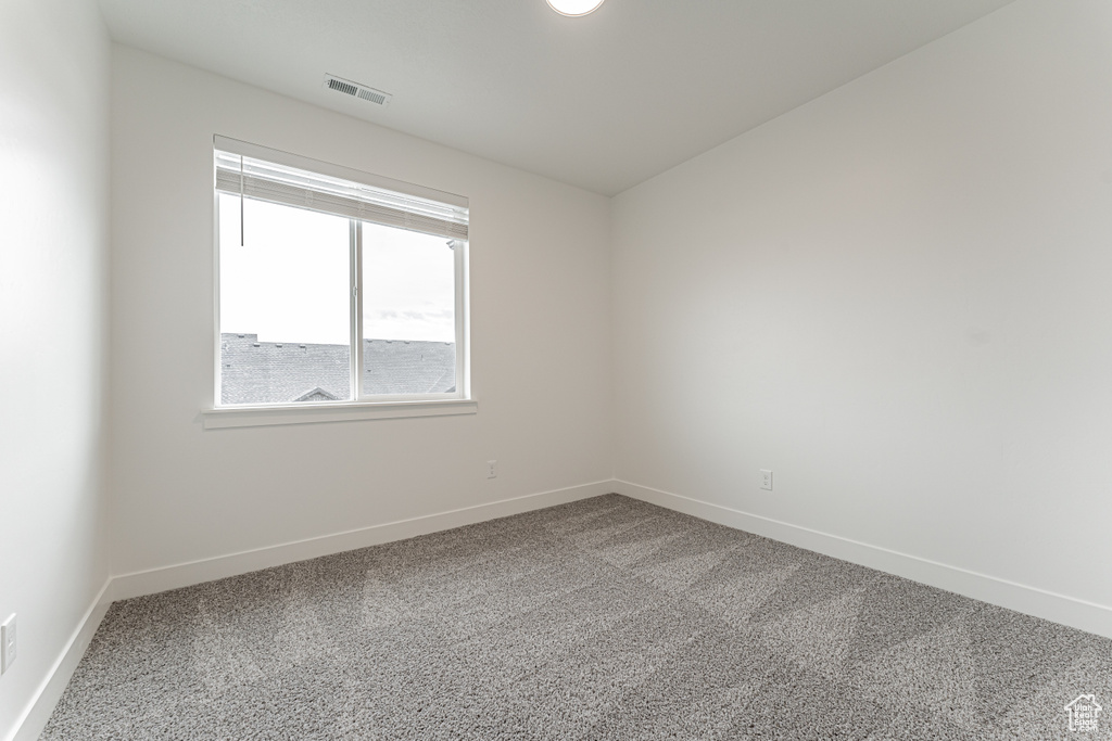 Unfurnished room with visible vents, baseboards, and carpet