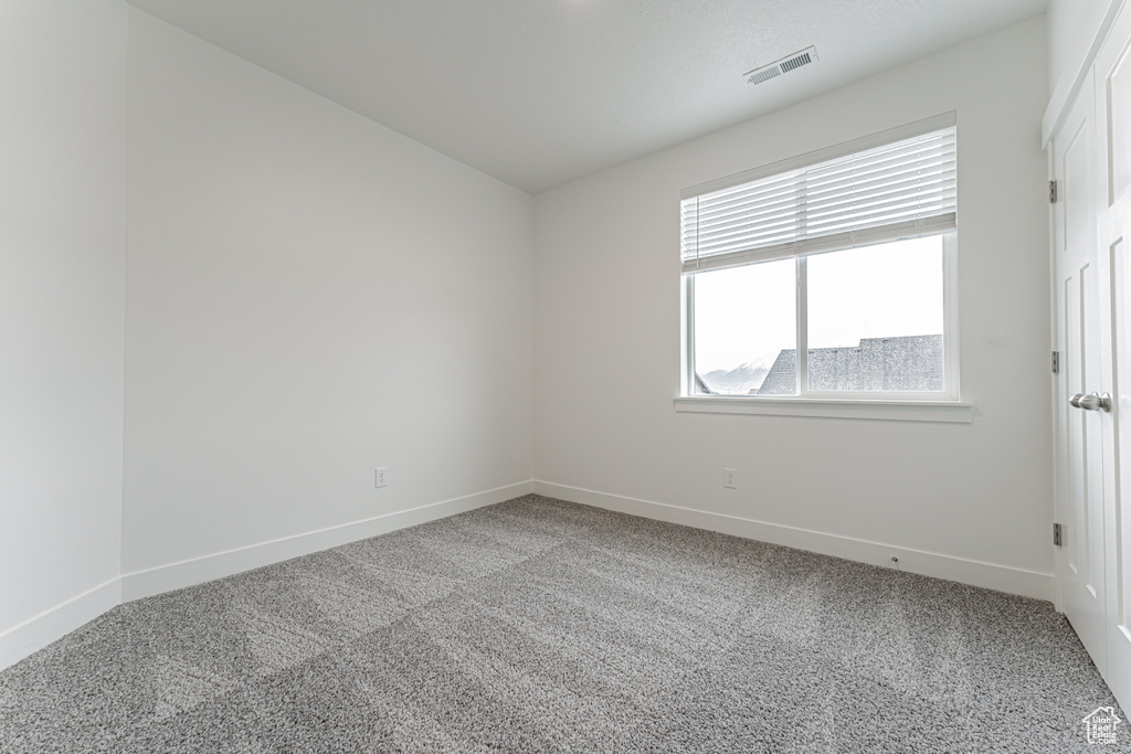 Unfurnished room with visible vents, carpet floors, and baseboards