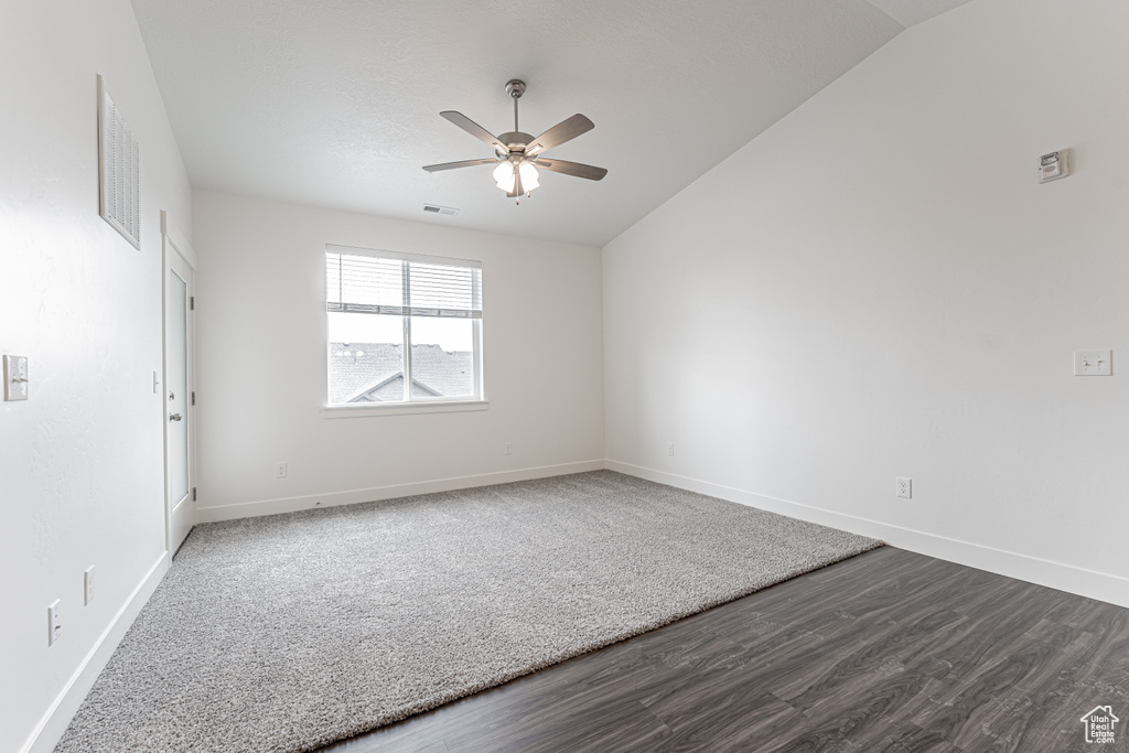 Unfurnished room with visible vents, baseboards, ceiling fan, and dark wood-style flooring