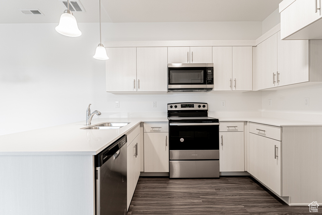 Kitchen with light countertops, visible vents, appliances with stainless steel finishes, and a sink