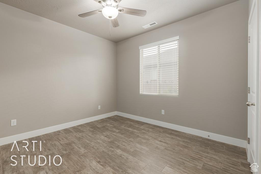 Spare room with hardwood / wood-style flooring and ceiling fan