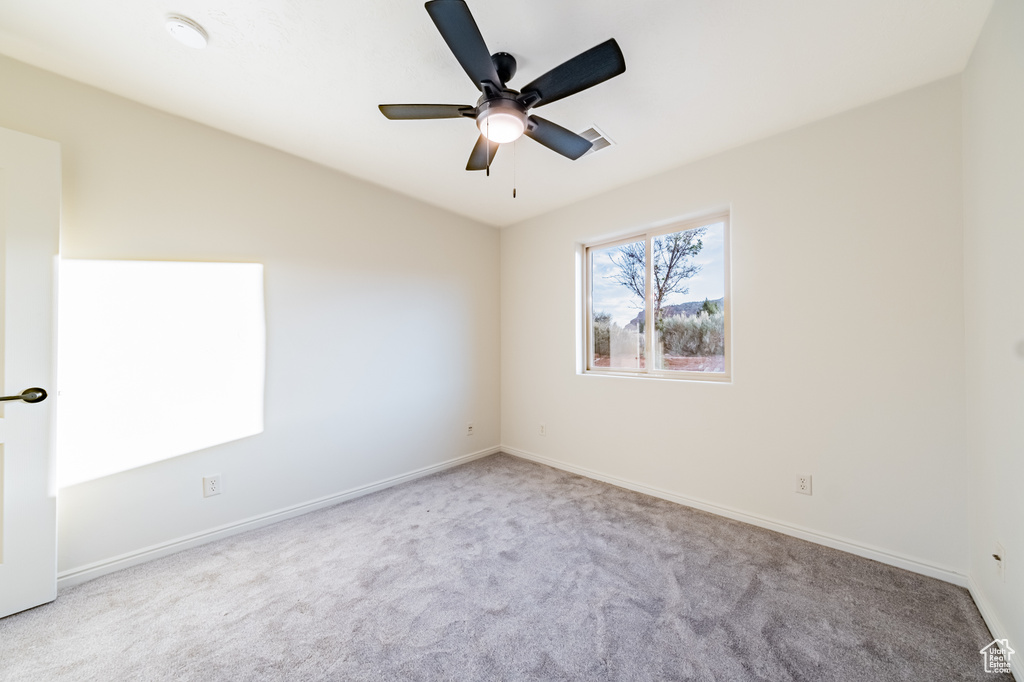 Empty room featuring ceiling fan and light colored carpet