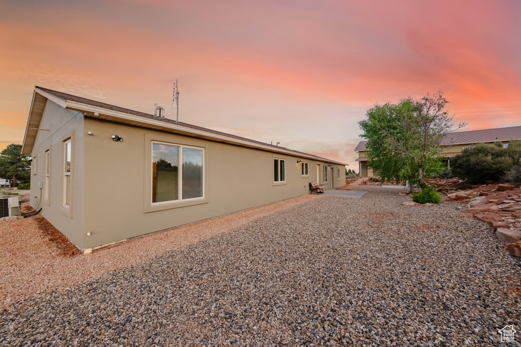 Back house at dusk with central air condition unit