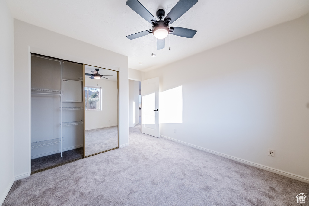 Unfurnished bedroom featuring a closet, carpet, and ceiling fan