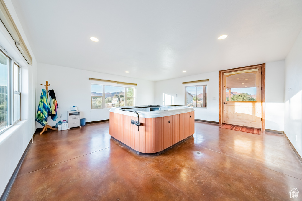 Kitchen with an island with sink, light brown cabinets, and a wealth of natural light