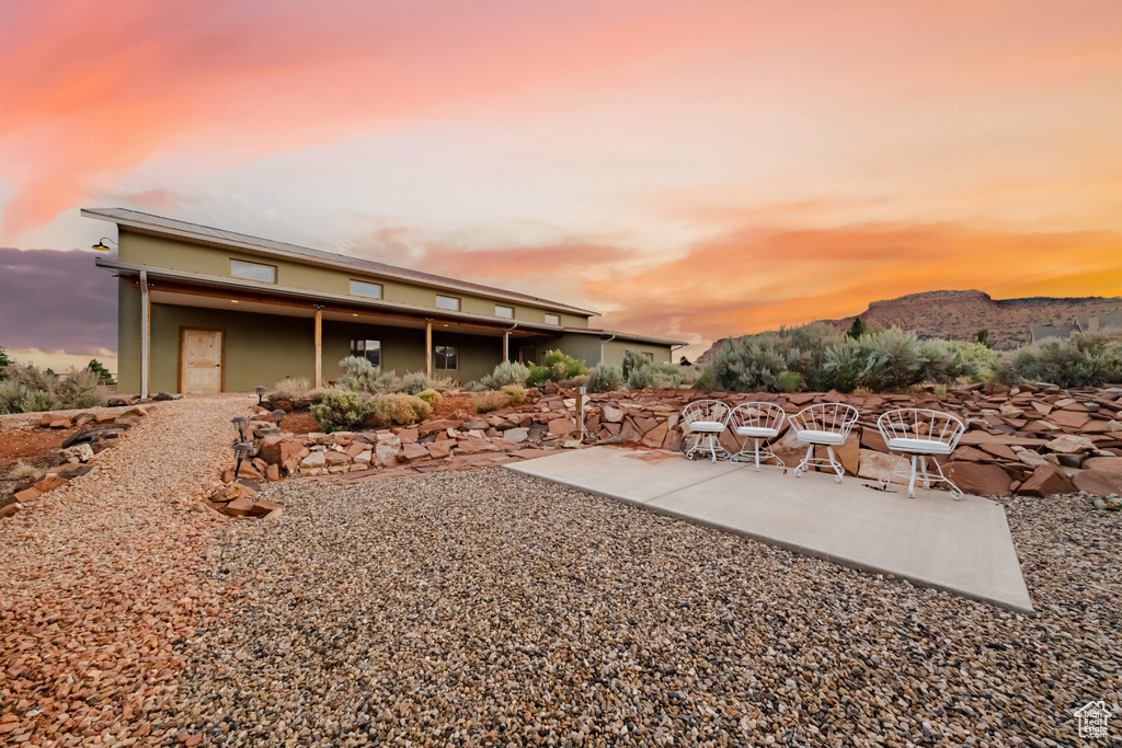 Yard at dusk featuring a mountain view and a patio area