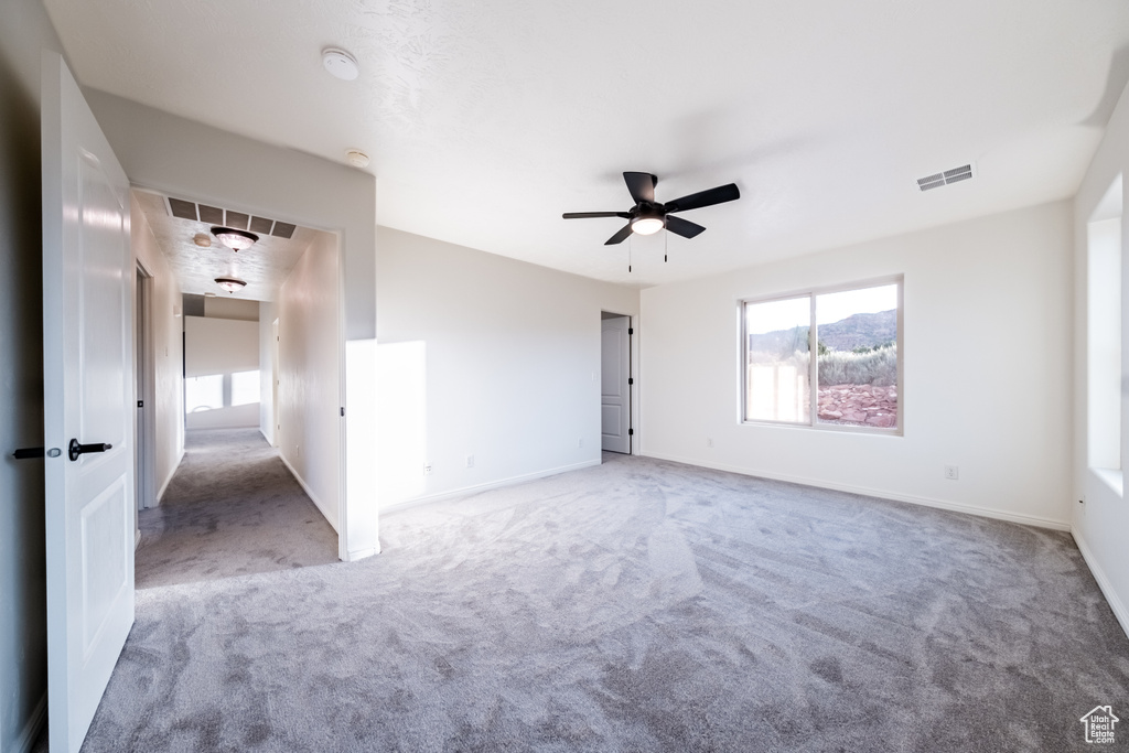 Unfurnished room featuring carpet and ceiling fan