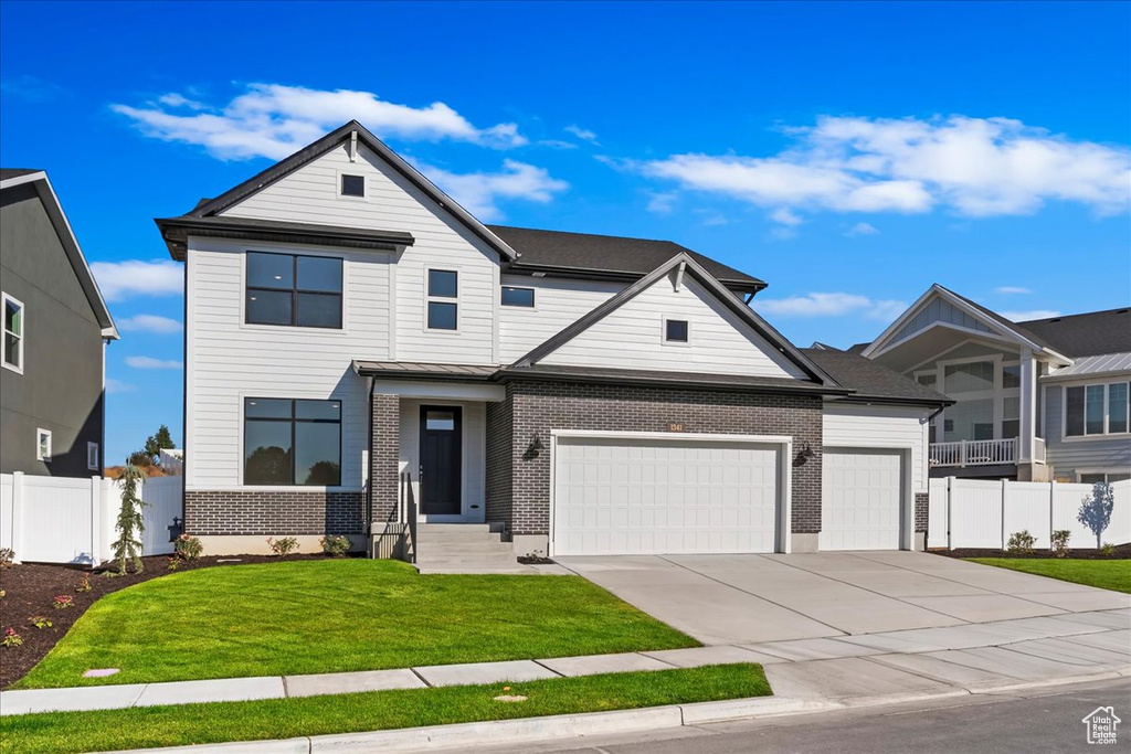 View of front of home featuring a front lawn and a garage