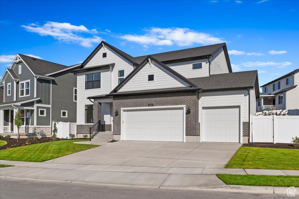 View of front of home with a garage and a front lawn