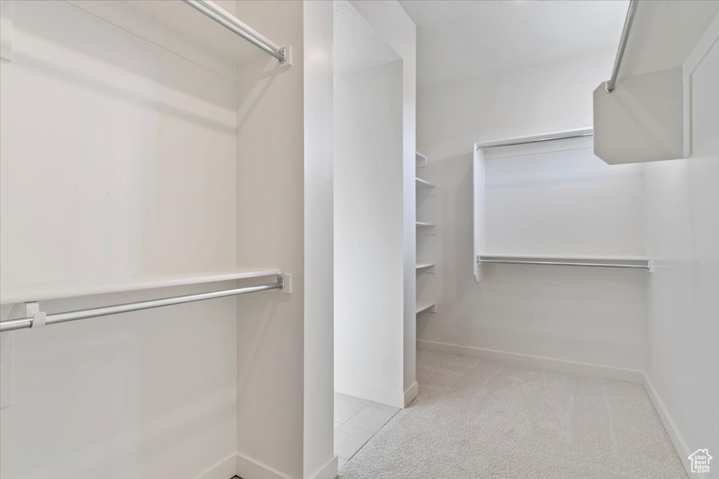 Walk in closet featuring light colored carpet