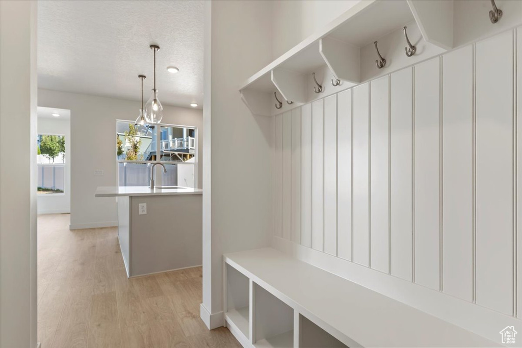 Mudroom with a textured ceiling and light wood-type flooring