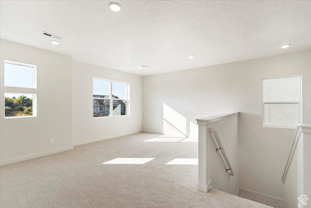 Carpeted spare room with a textured ceiling