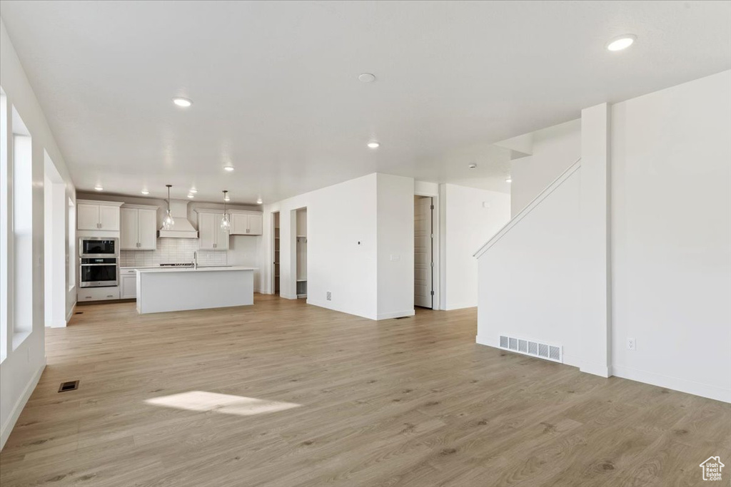 Unfurnished living room featuring light wood-type flooring