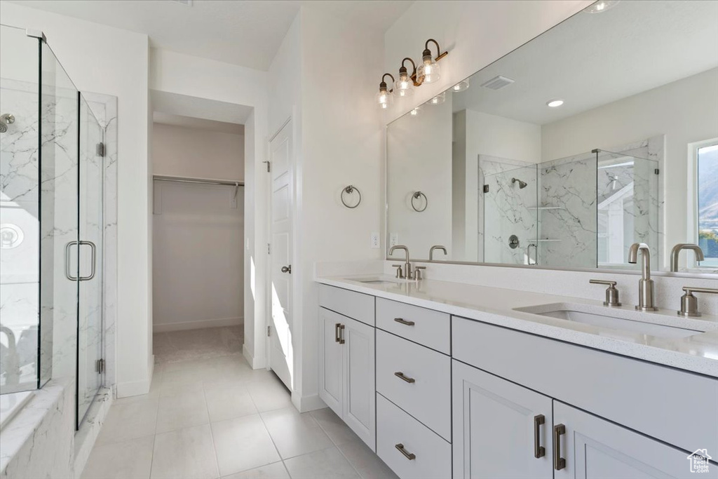 Bathroom featuring vanity, an enclosed shower, and tile patterned floors