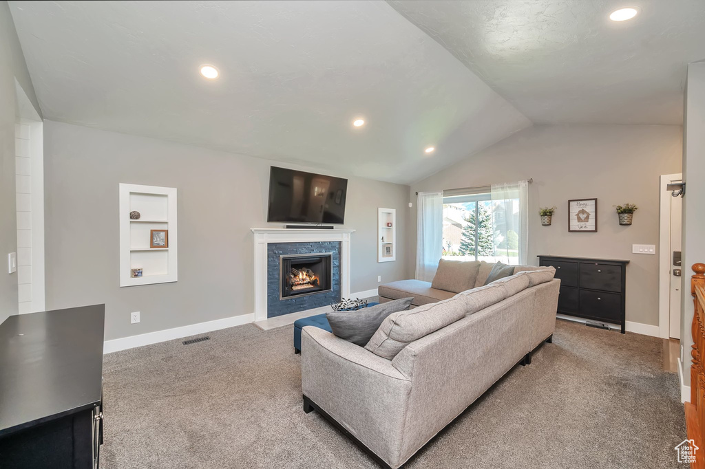 Carpeted living room featuring vaulted ceiling