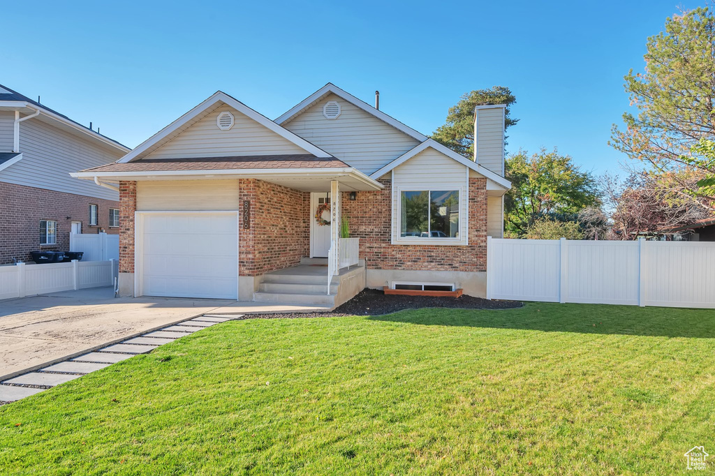 View of front of property featuring a front yard and a garage