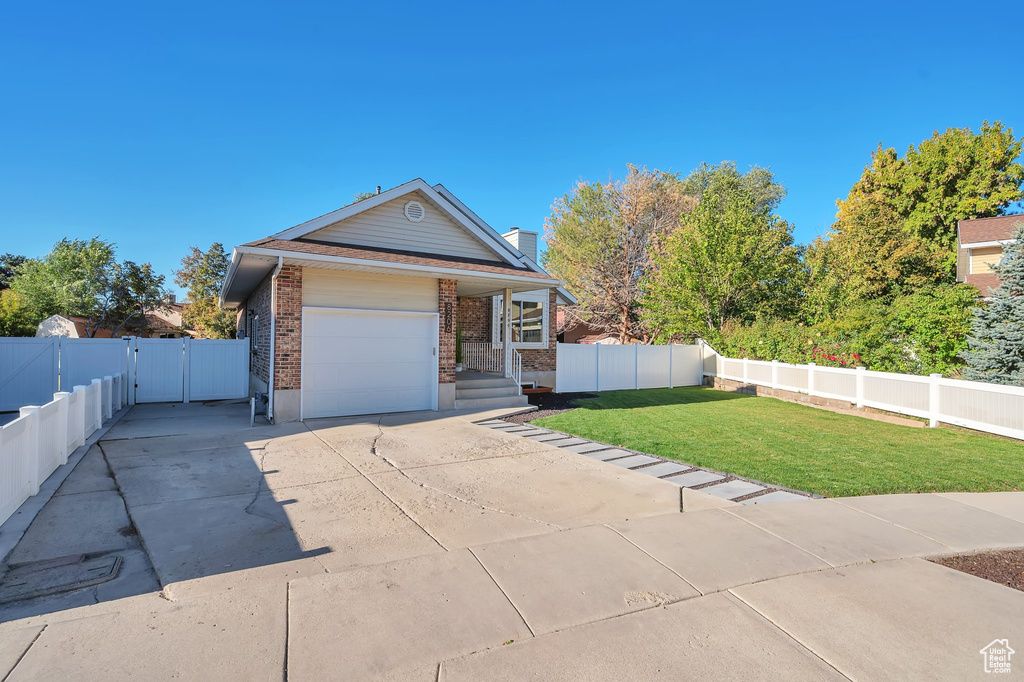 View of front of home with a front lawn and a garage