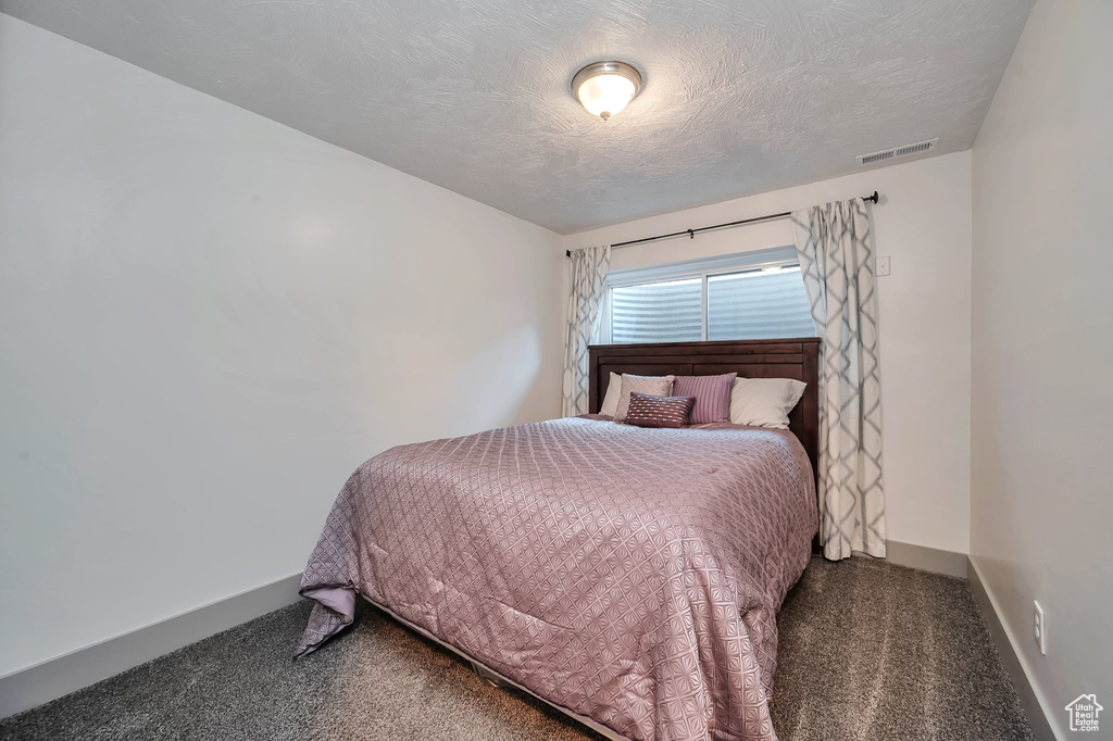 Carpeted bedroom with a textured ceiling