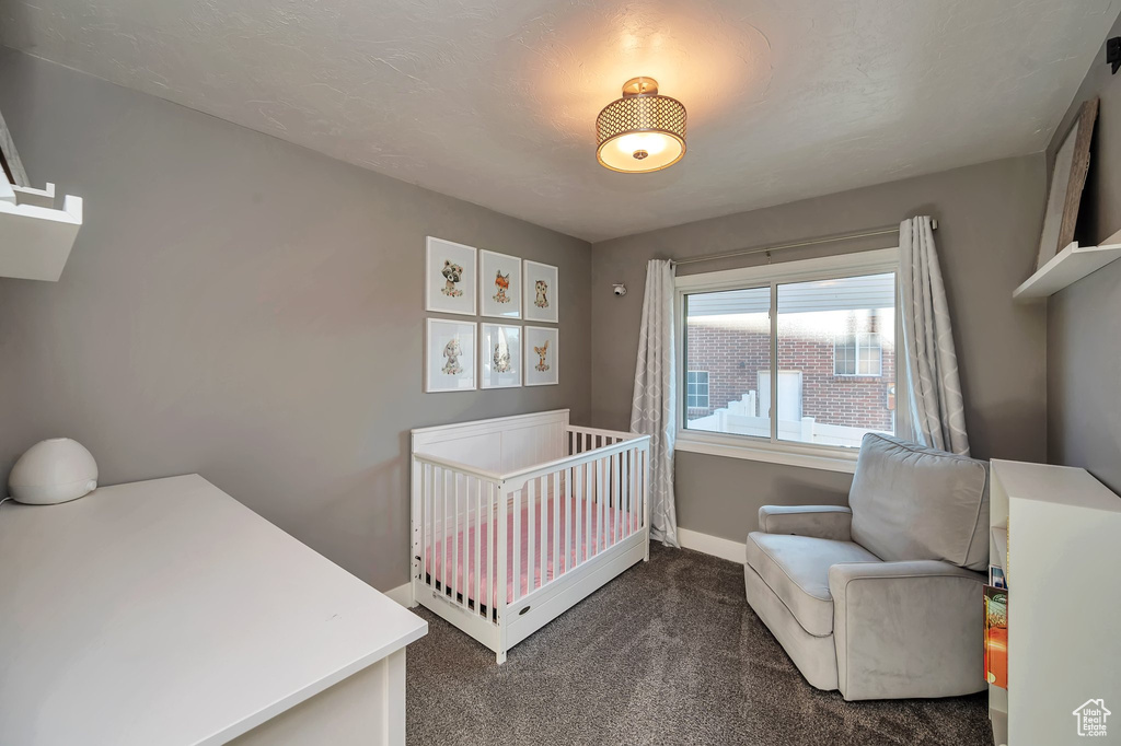 Carpeted bedroom with a nursery area and a textured ceiling