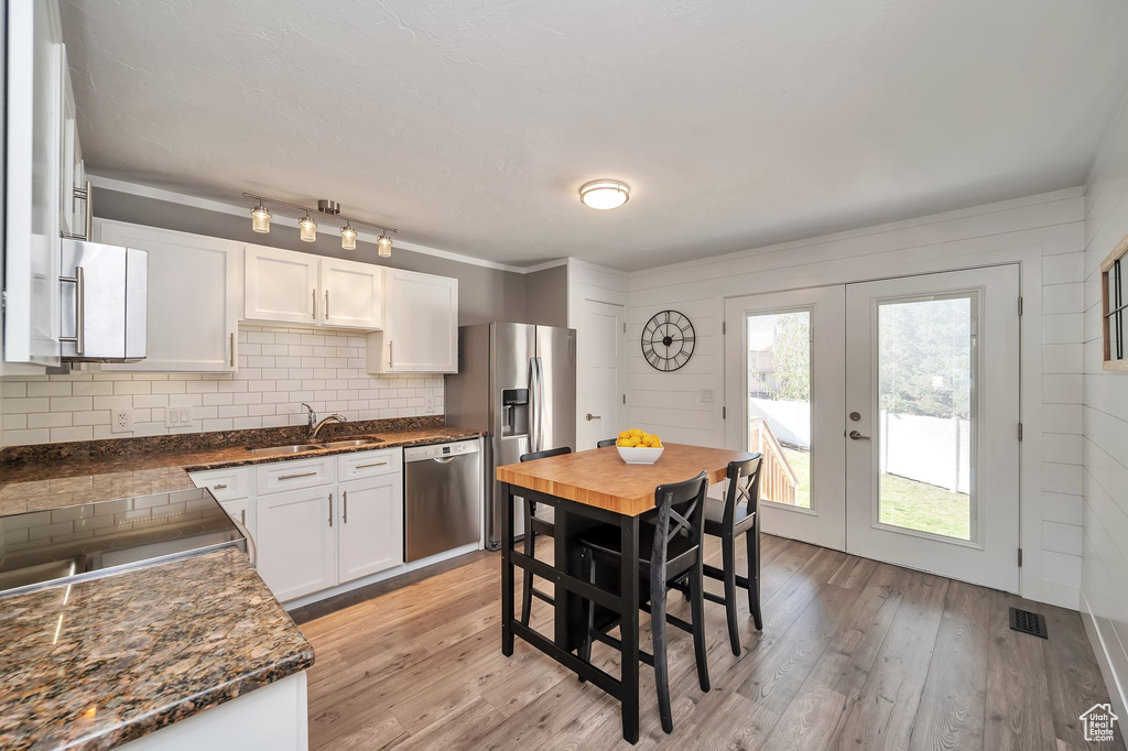 Kitchen with sink, french doors, light hardwood / wood-style floors, stainless steel appliances, and white cabinets