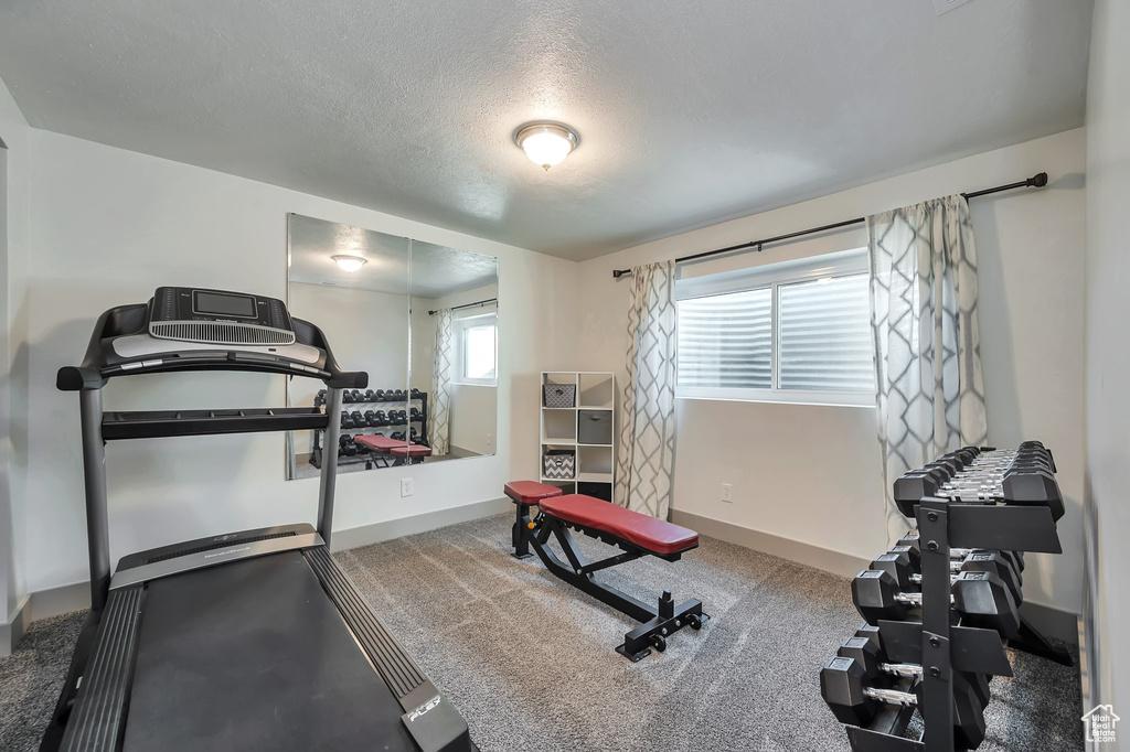 Workout area featuring a textured ceiling and carpet floors