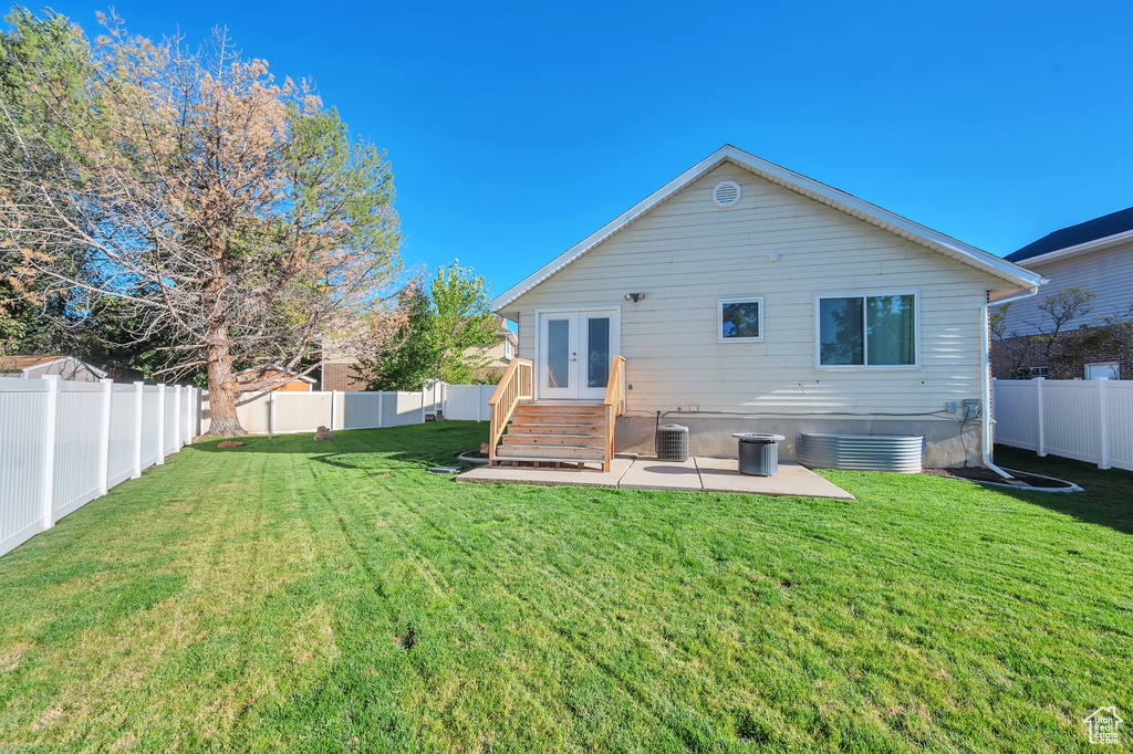 Back of house with a yard, a patio area, and cooling unit