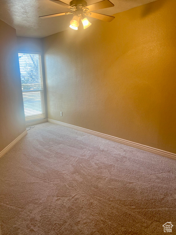 Carpeted empty room featuring ceiling fan and a textured ceiling