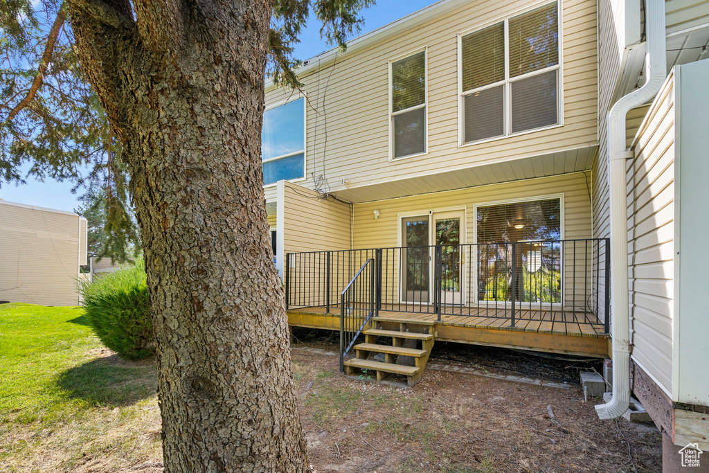 Back of house featuring a deck and a lawn