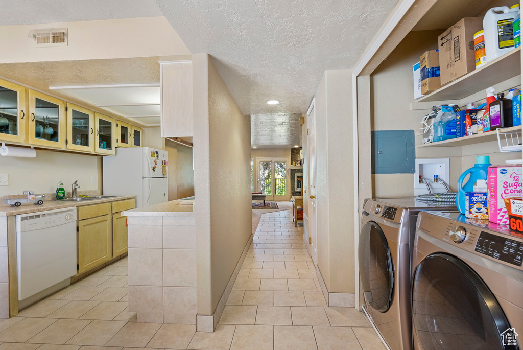 Laundry room featuring sink, electric panel, a textured ceiling, and light tile patterned floors