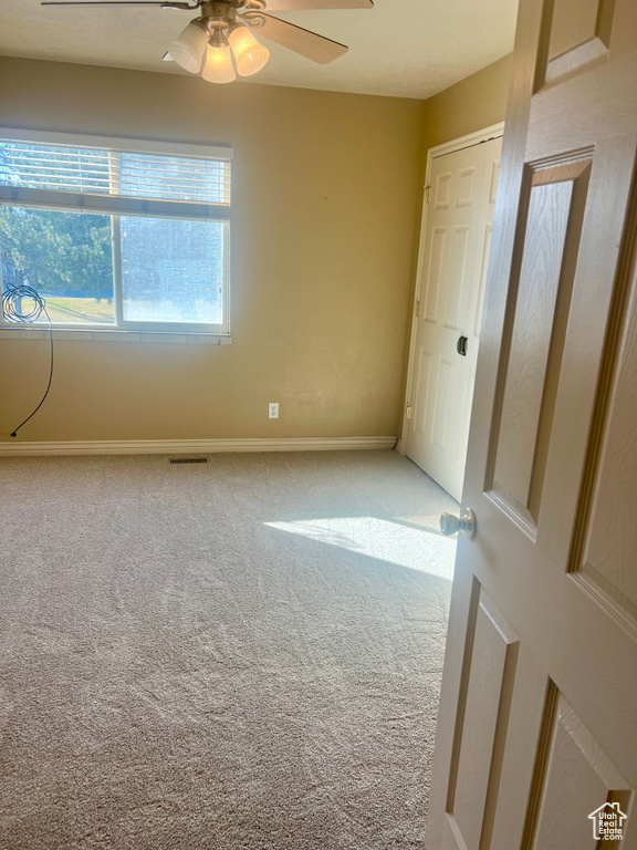 Unfurnished room featuring carpet and ceiling fan