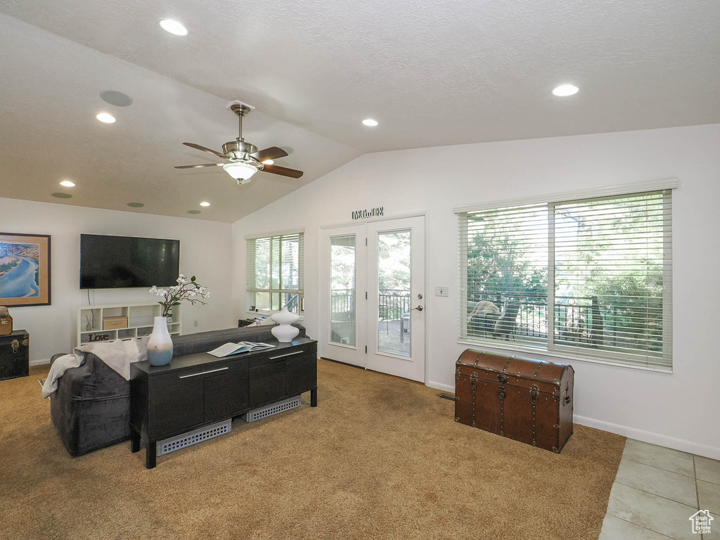 Carpeted living room with lofted ceiling, a healthy amount of sunlight, and ceiling fan