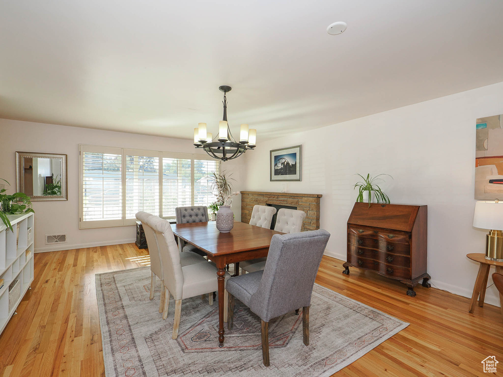 Dining space with a notable chandelier and light wood-type flooring