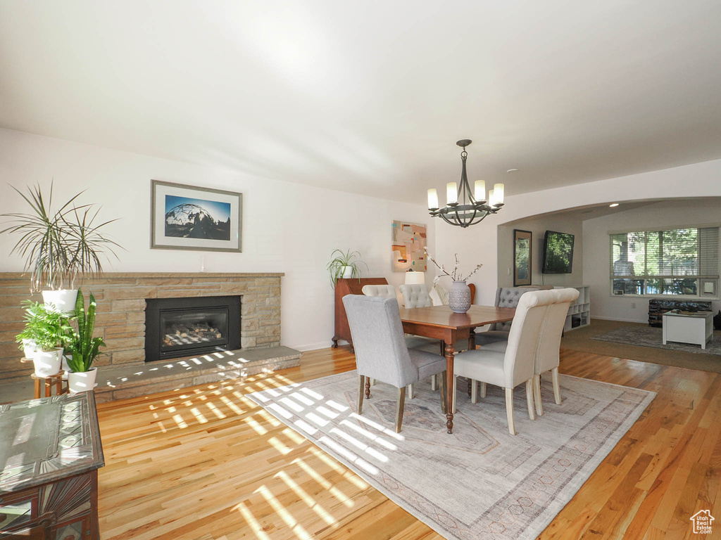 Dining area featuring a notable chandelier, hardwood / wood-style floors, and a fireplace