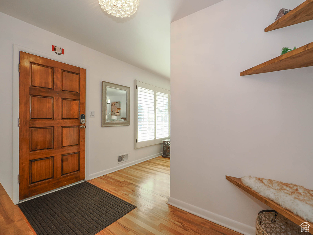 Entryway with light hardwood / wood-style flooring and a notable chandelier