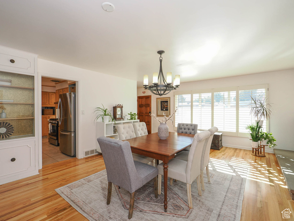 Dining area with light hardwood / wood-style flooring and a chandelier