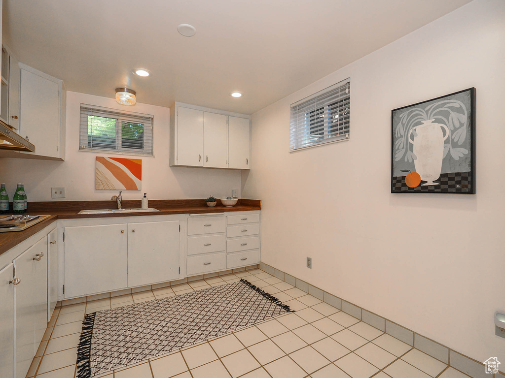 Kitchen with sink, white cabinetry, stainless steel gas cooktop, and light tile patterned flooring