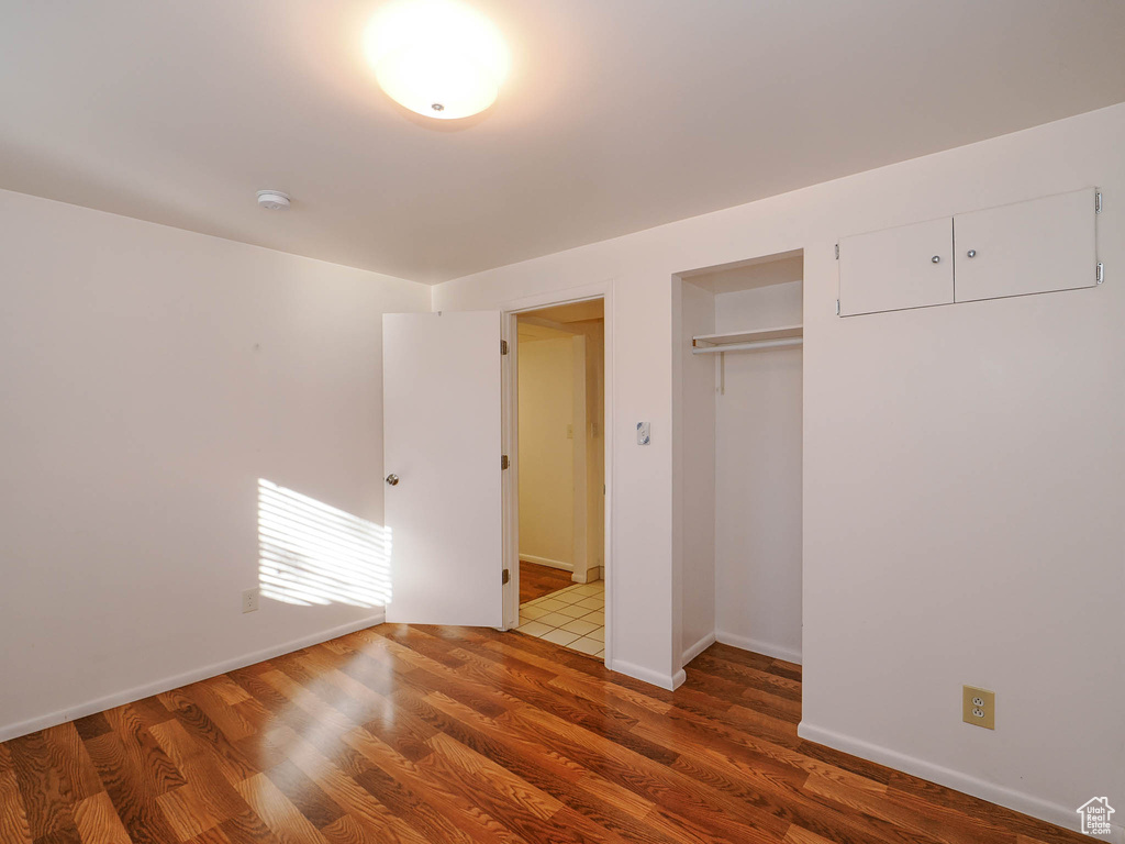 Unfurnished bedroom with a closet and hardwood / wood-style floors