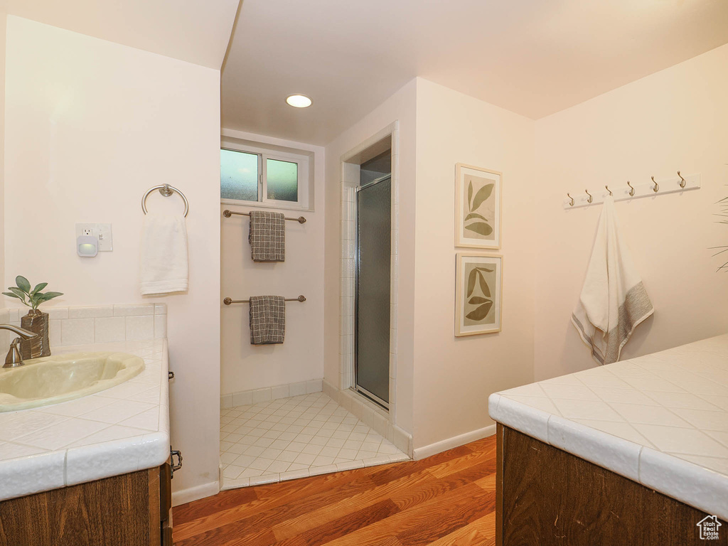 Bathroom featuring vanity, hardwood / wood-style flooring, and an enclosed shower