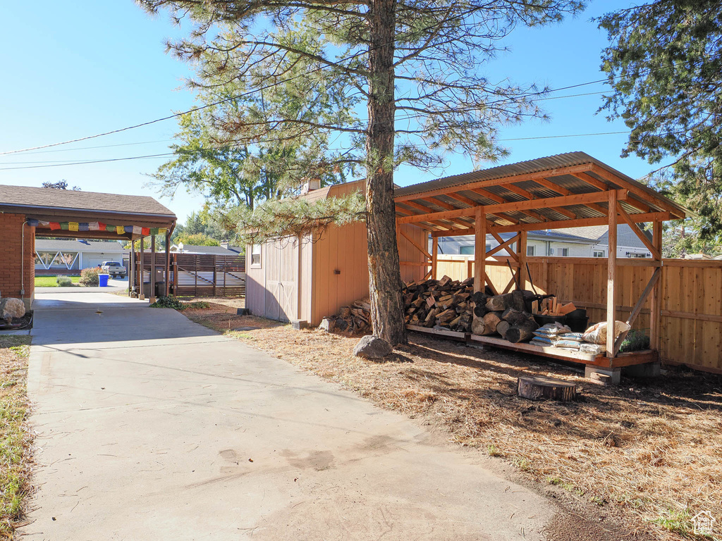 Exterior space with a storage unit and a carport