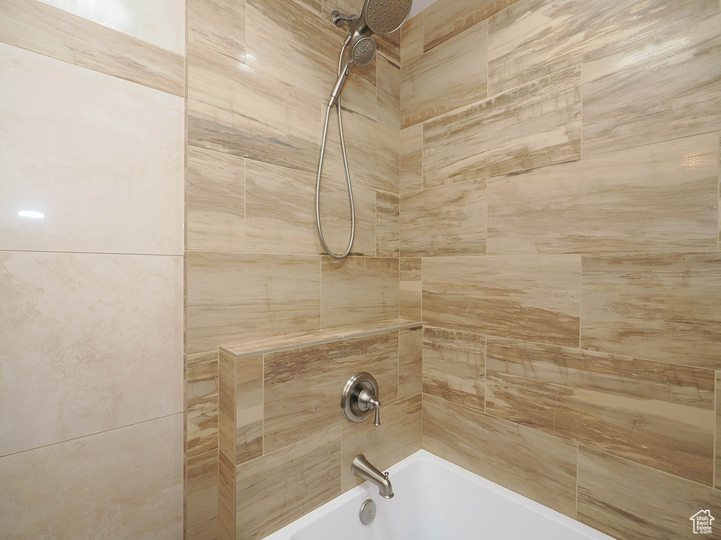 Room details featuring tiled shower / bath combo