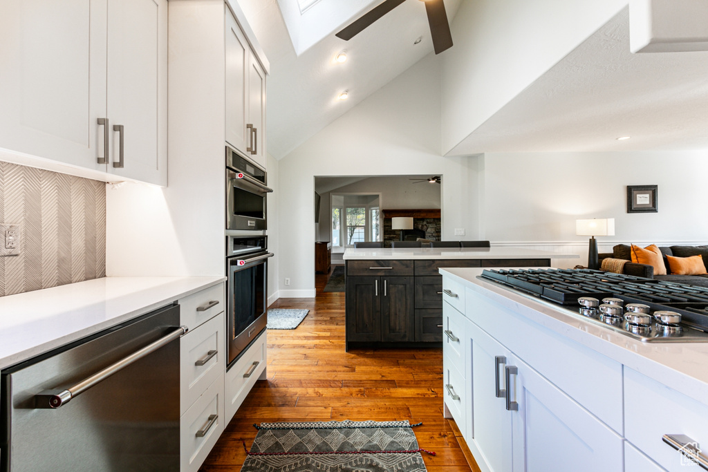 Kitchen featuring appliances with stainless steel finishes, white cabinetry, hardwood / wood-style flooring, and ceiling fan