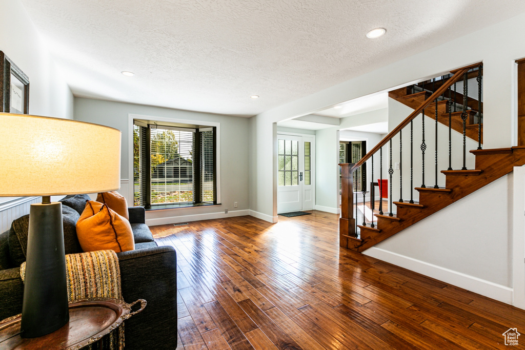 Living room featuring a textured ceiling and hardwood / wood-style flooring