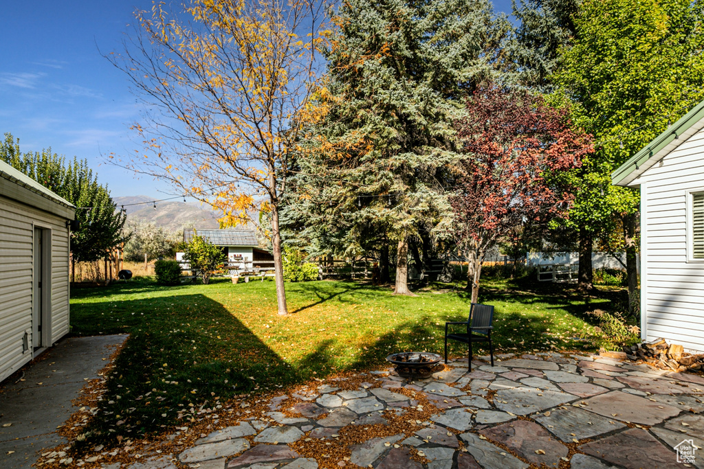 View of yard with a mountain view, a patio, and a fire pit