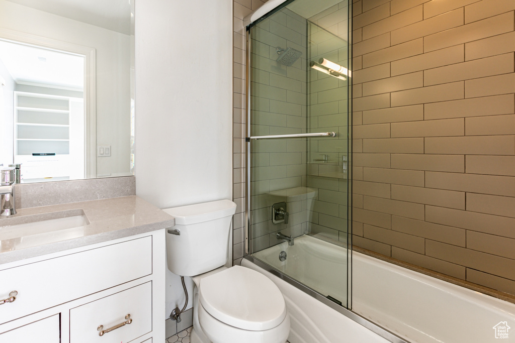 Full bathroom with vanity, toilet, and enclosed tub / shower combo